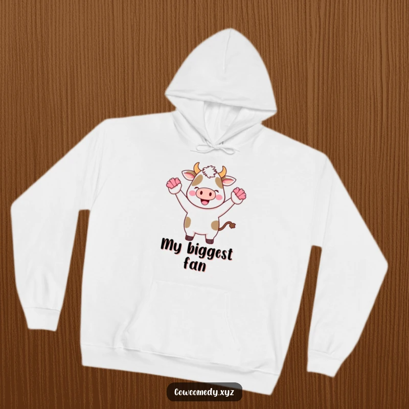 Funny Kawaii Cow Hoodie depicting a cute cartoon cow cheering with tiny pom-poms, cozy and full of energy.