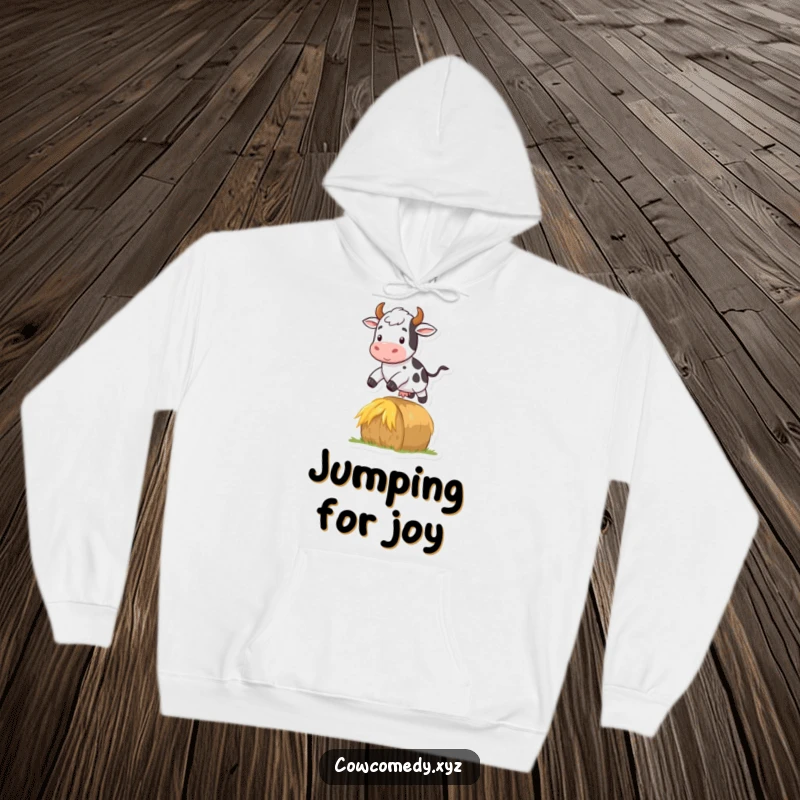 Funny hoodie featuring a cow leaping over a hay bale, embodying energy, fun, and a touch of farm athleticism.