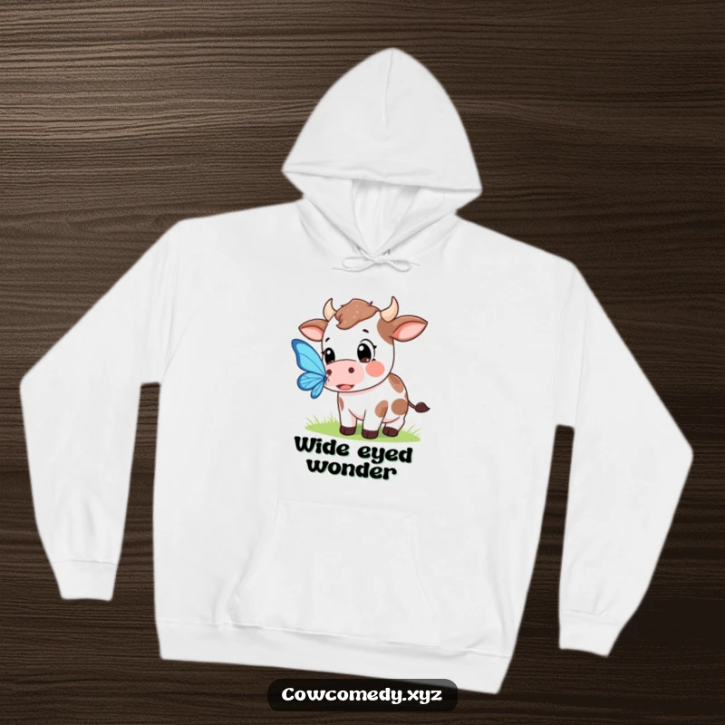 Funny hoodie showing a Kawaii cow with large, expressive eyes focused on catching a beautiful butterfly in a whimsical scene.