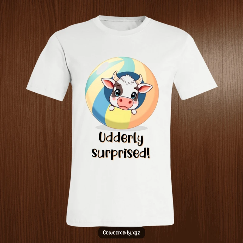 Funny T-Shirt: A surprised cow peeking out from behind a giant striped beach ball, showing comical beach day astonishment.