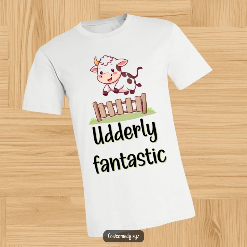 Funny T-shirt graphic of a happy cow soaring joyfully over a small, simple fence.